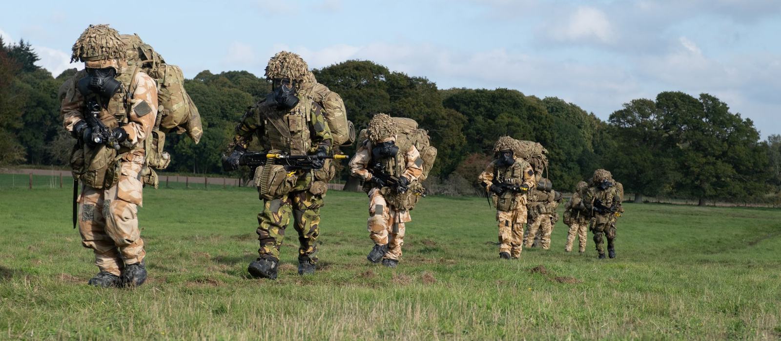 Soldiers dispersed across open ground during a field exercise